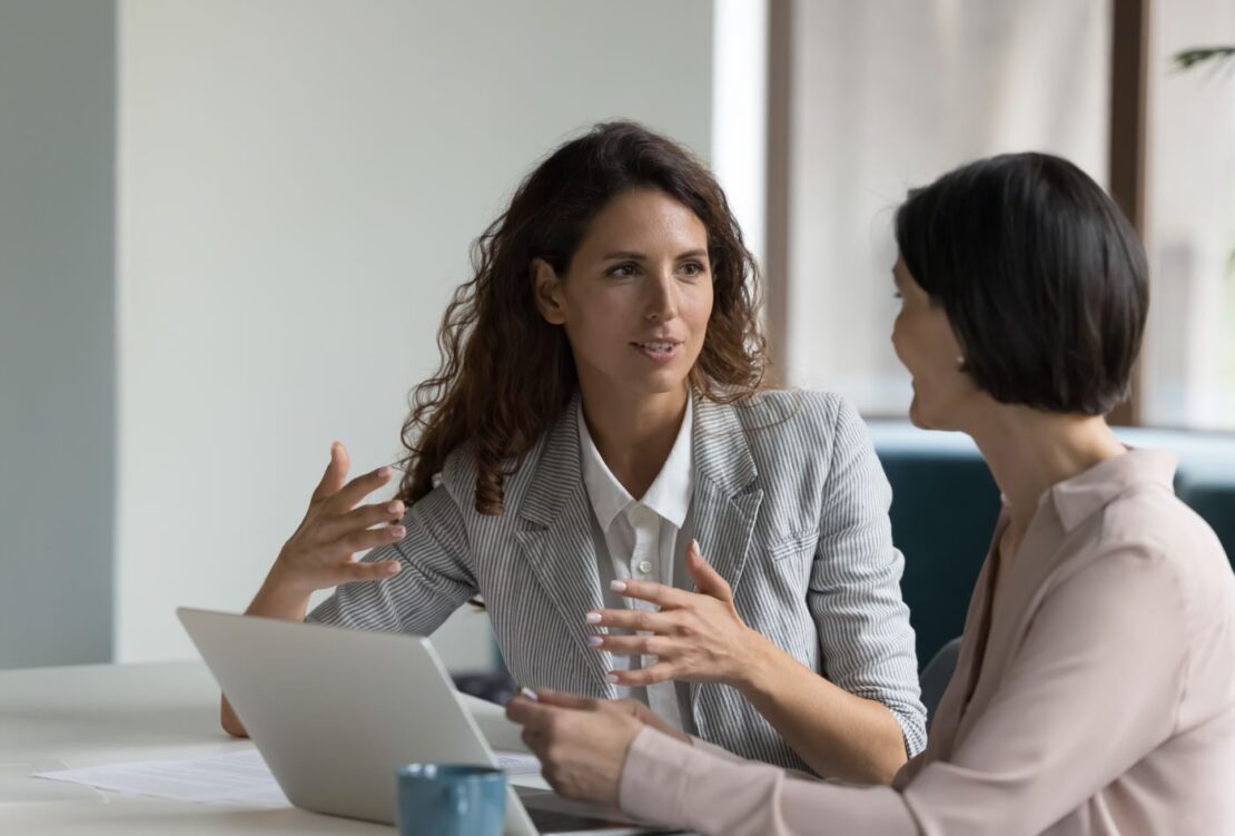 Two female innovators discussing ideas in an office