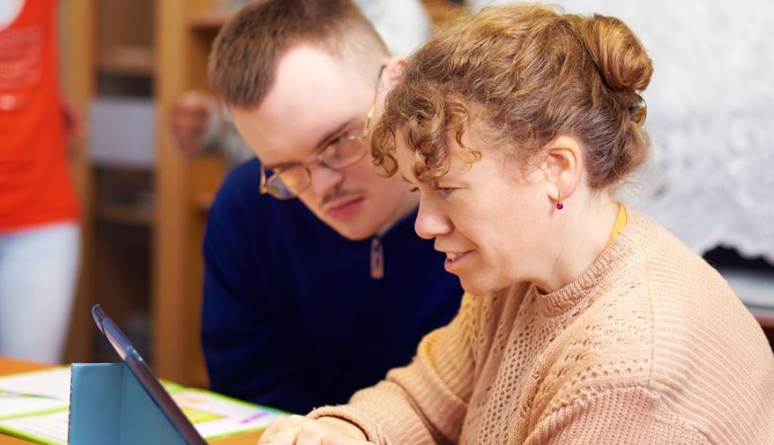 woman and man on ipad at care home
