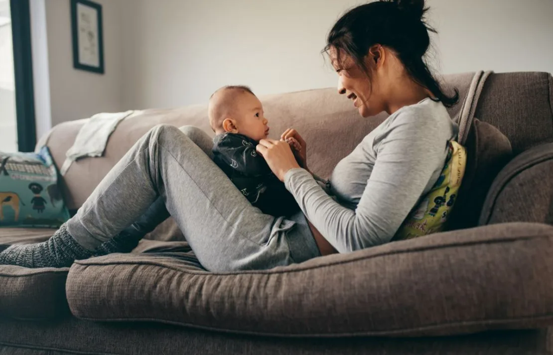 Woman with her baby on sofa