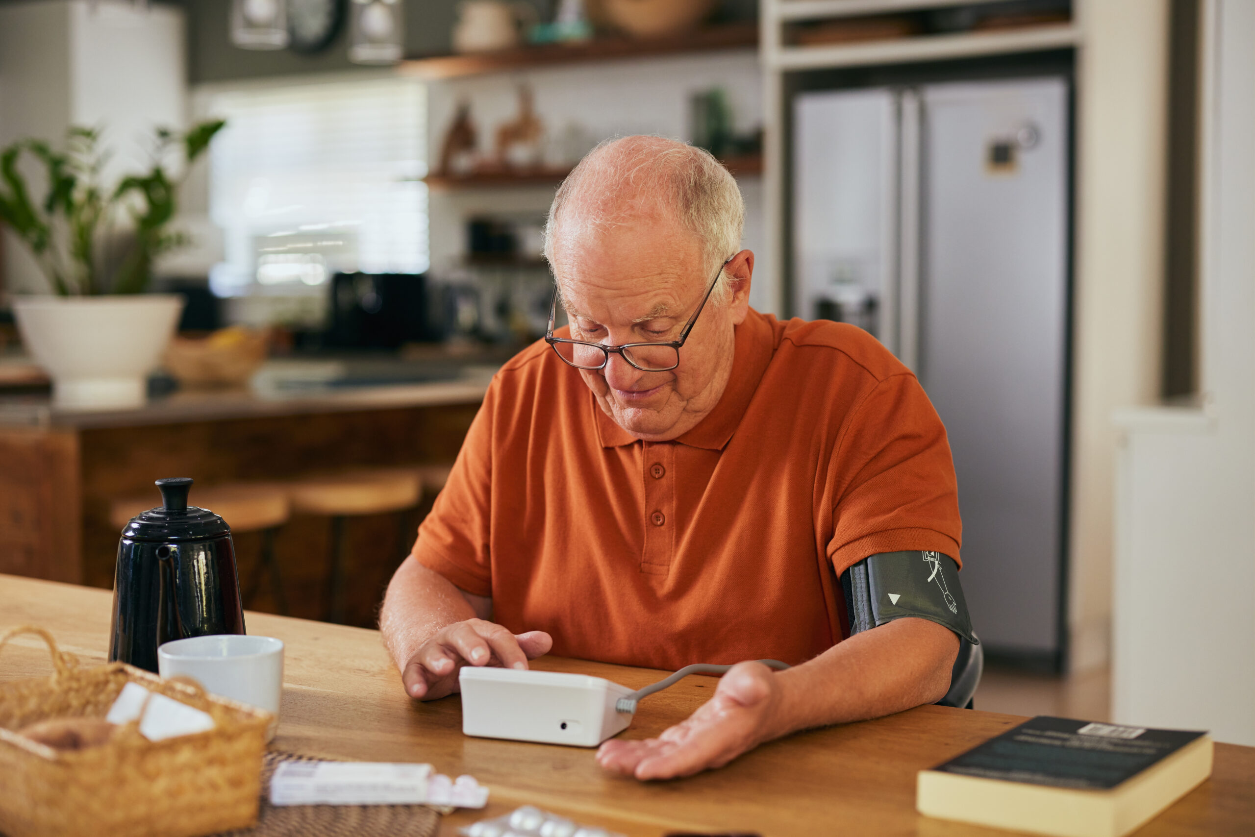 Older man measuring blood pressure at home