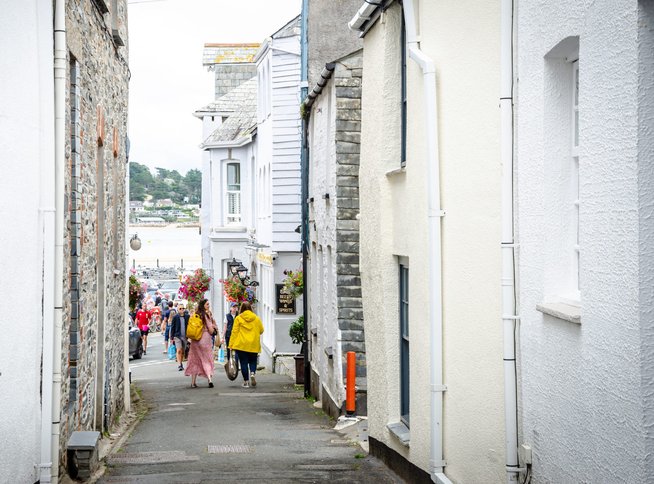 People walking the streets of Padstow, Cornish town with sea view