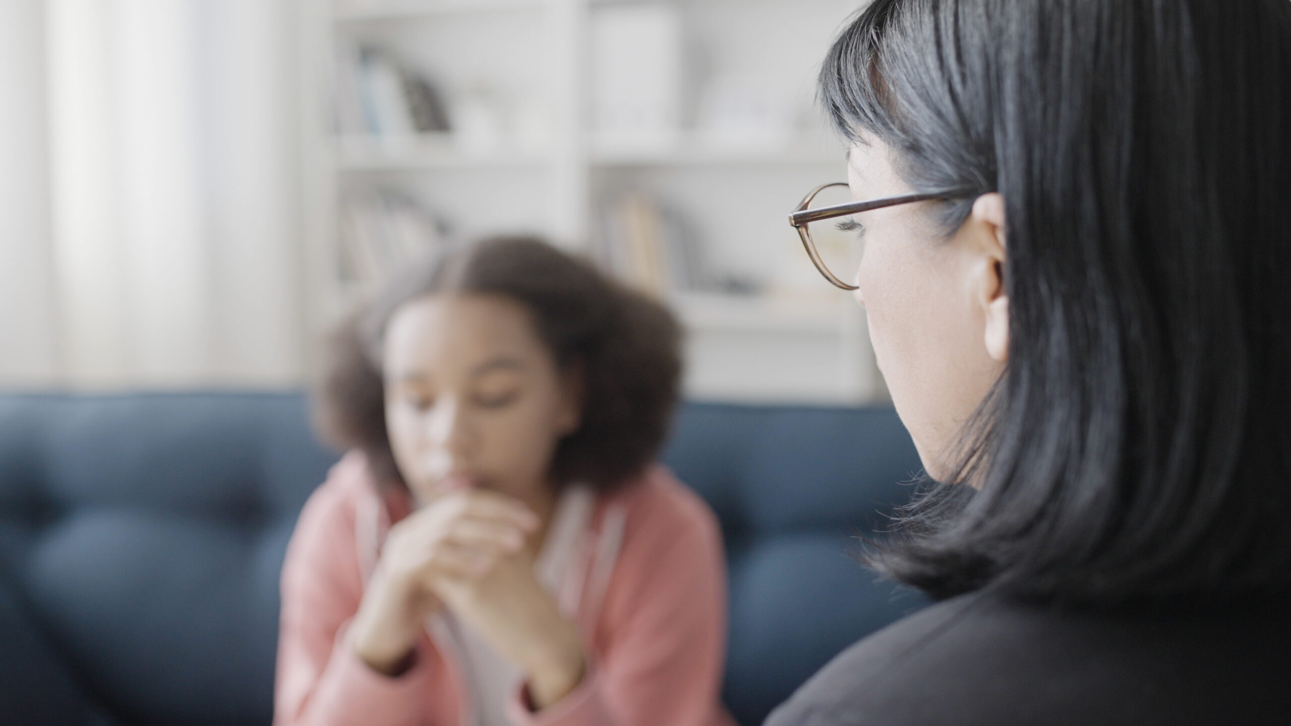 A woman speaks to a young teenage girl in crisis
