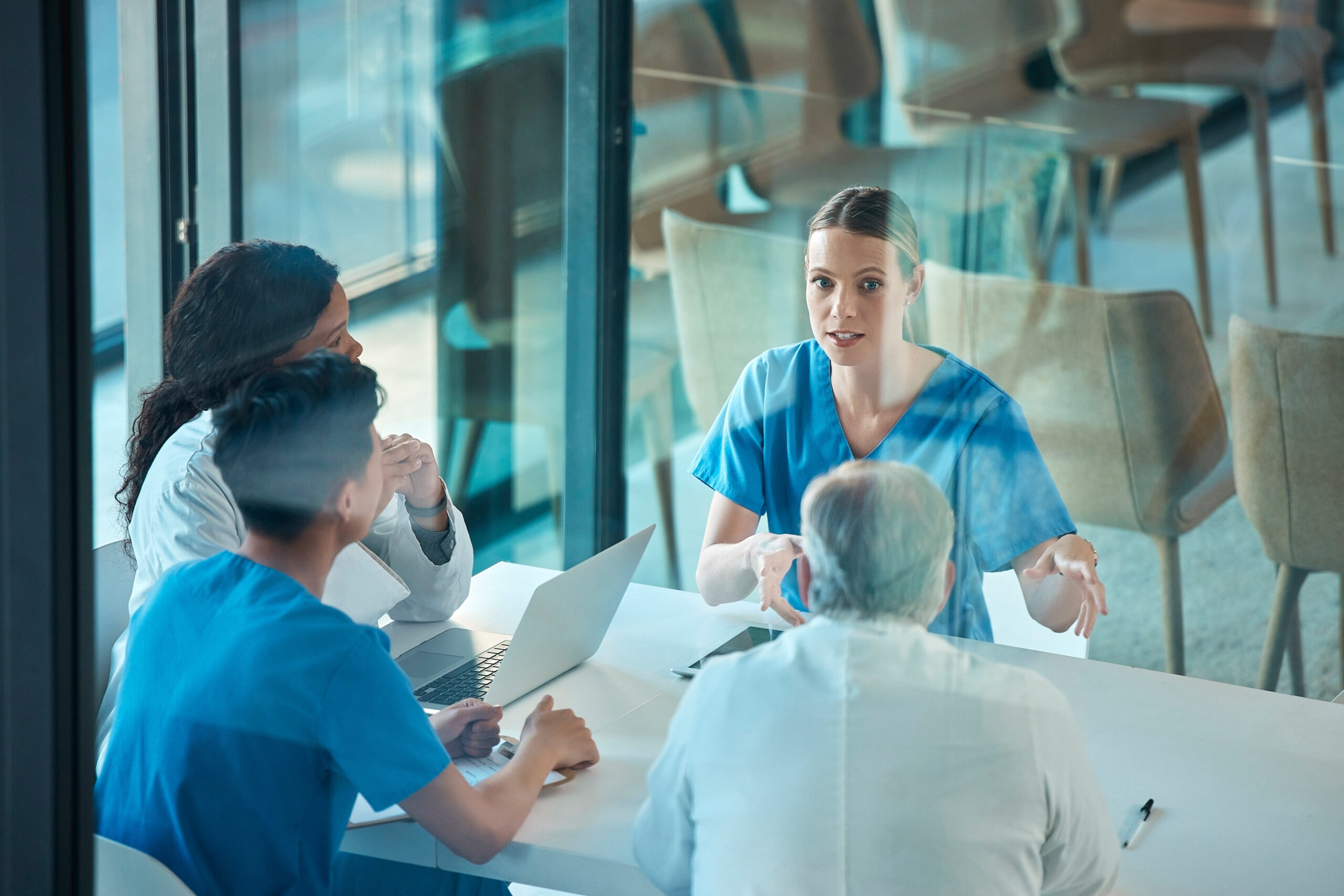 Group of health and care staff have a discussion together at a table
