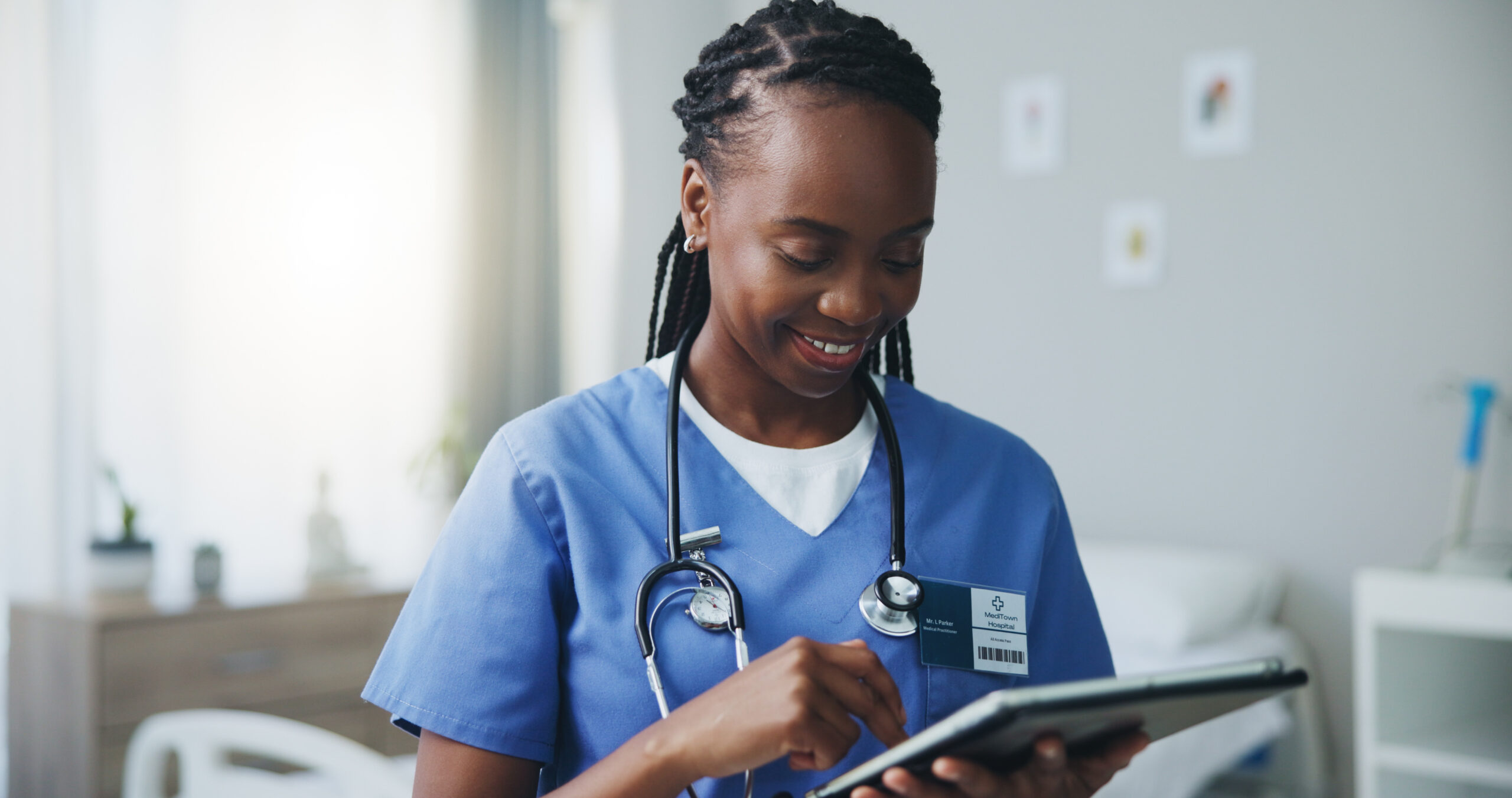 Doctor smiling using app on tablet in hospital setting
