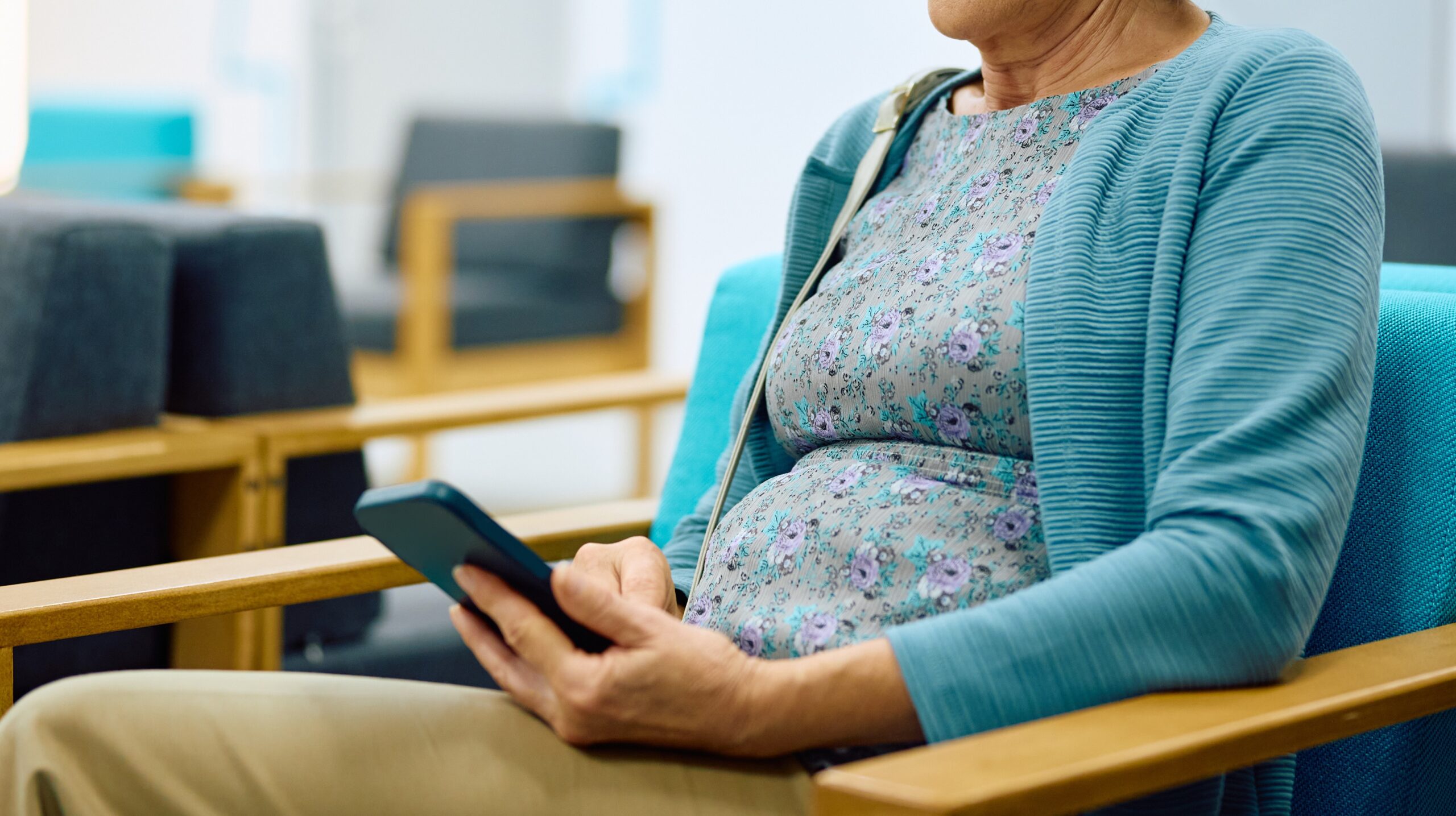 A woman in hospital waiting room on her mobile phone