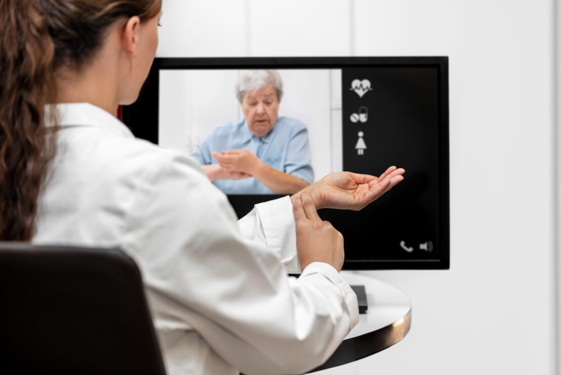 A doctor conducts a video consultation with a patient on her computer