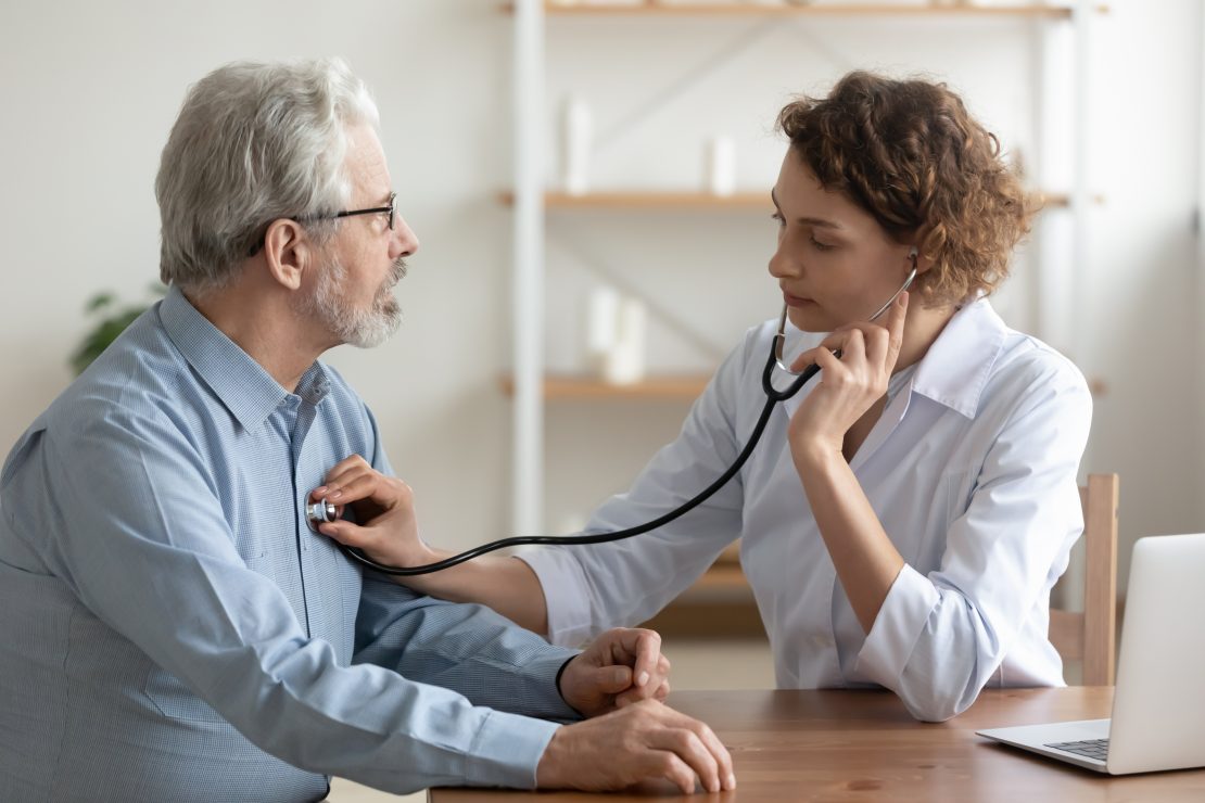 Female cardiologist checks a patient's heart
