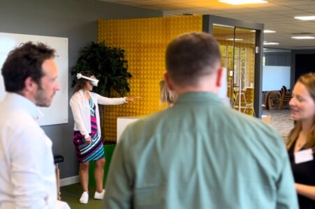 a group of people surround someone using a virtual reality headset