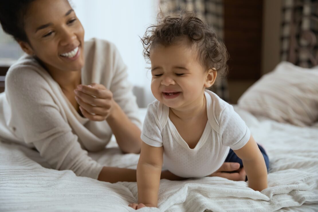 Happy mum playing with child in their bedroom